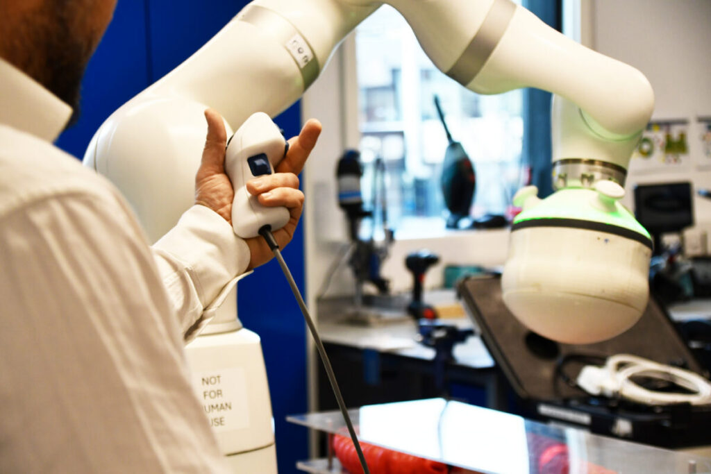 An image of a person using a piece of lab medical equipment with their hand visible using a hand-operated control device.